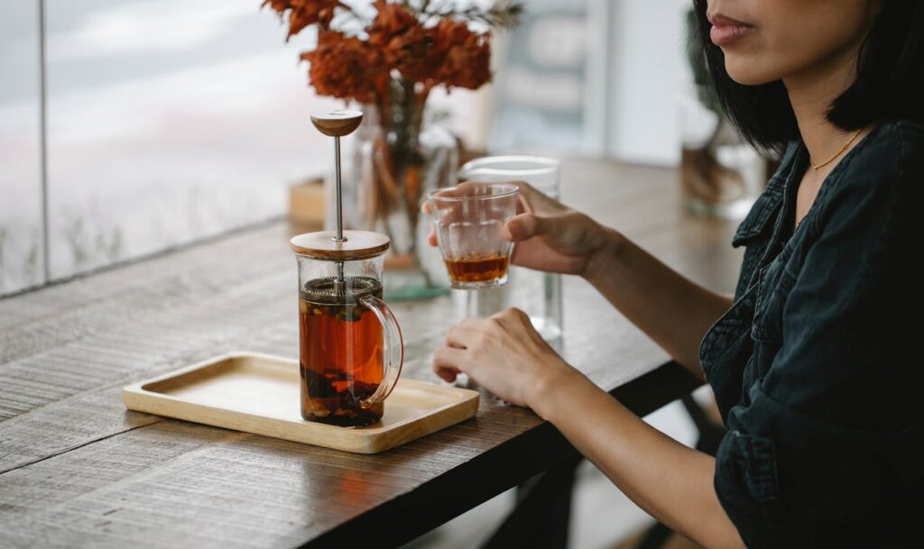 tee kann naine laud Photo by Charlotte May: https://www.pexels.com/photo/crop-woman-enjoying-herbal-tea-at-high-table-5946805/