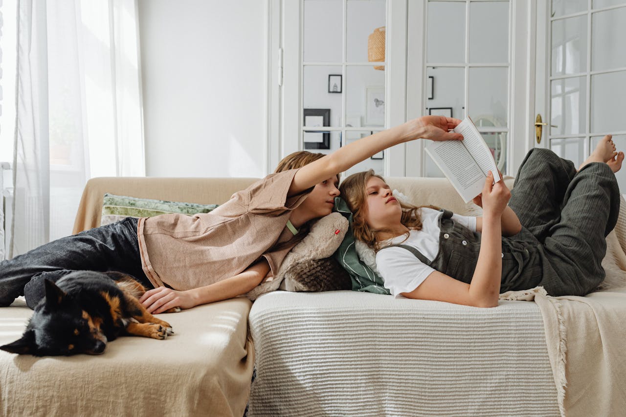 Photo by Karolina Grabowska: https://www.pexels.com/photo/siblings-lying-on-the-couch-7693125/ kaks noort diivanil